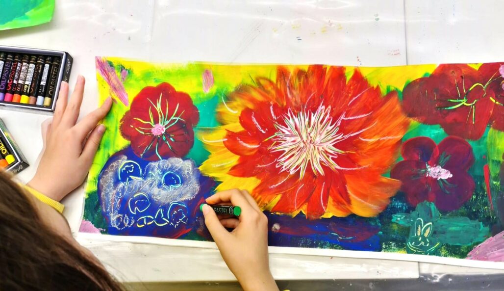 Kuvataidekoulun oppilas piirtää kukkia.