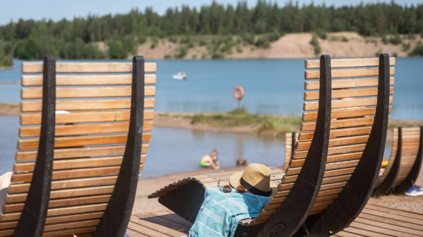 Aurinkoisen päivän rantakuva järvelle päin, etualalla kaksi rantatuolia.