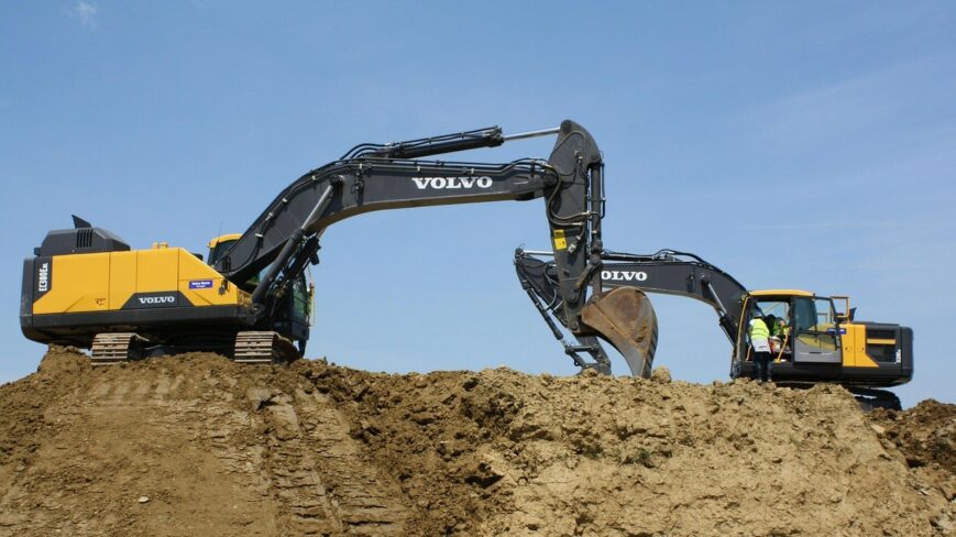 maakasan päällä kaksi keltamustaa kaivuria, kesä.