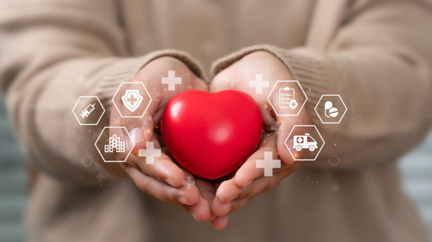 Hyvinvointikyselyyn liittyvä kuva, jossa henkilö pitää kädessään punaista sydämenmuotoista omenaa.