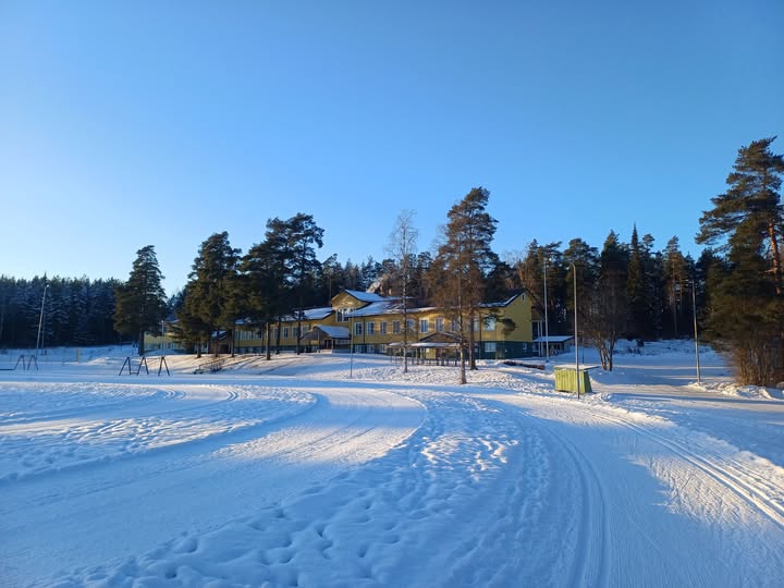 Alastasron kirkonkylän koulu taustalla ja edessä latua urheilukentällä.