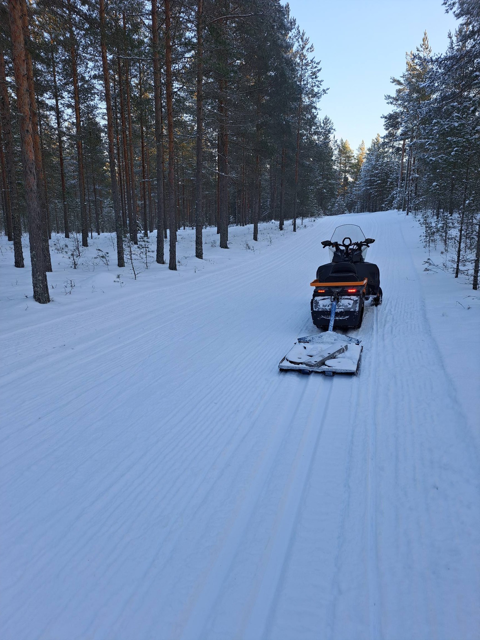 Kuva Harjureitiltä kuvassa on moottorikelkka latukone perässä.