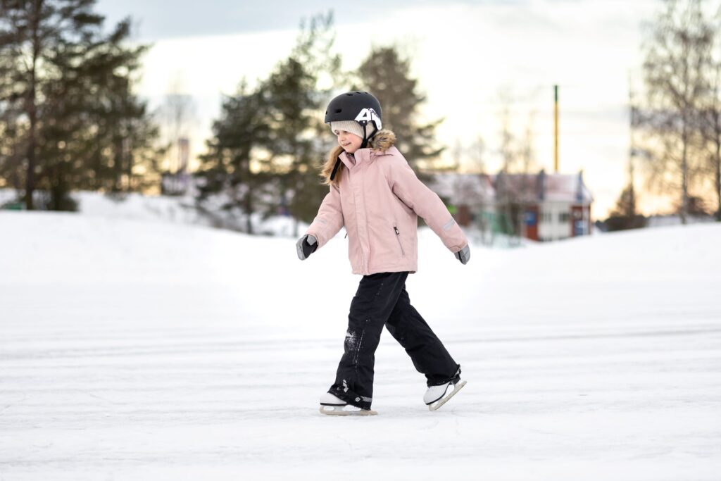 Kuvassa luistelijatyttö ulkojäillö harjoittelemassa.