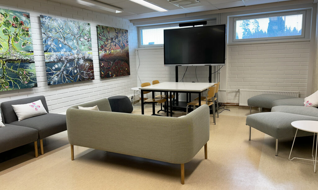 Kuvassa Hubi Loimaan yhteistyötila. Tilass sohvia, kosketusnäyttö, kokouspöytä ja seinillä taidetta.