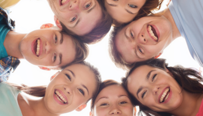 Ryhmä hymyileviä nuoria vierekkäin ympyrässä.