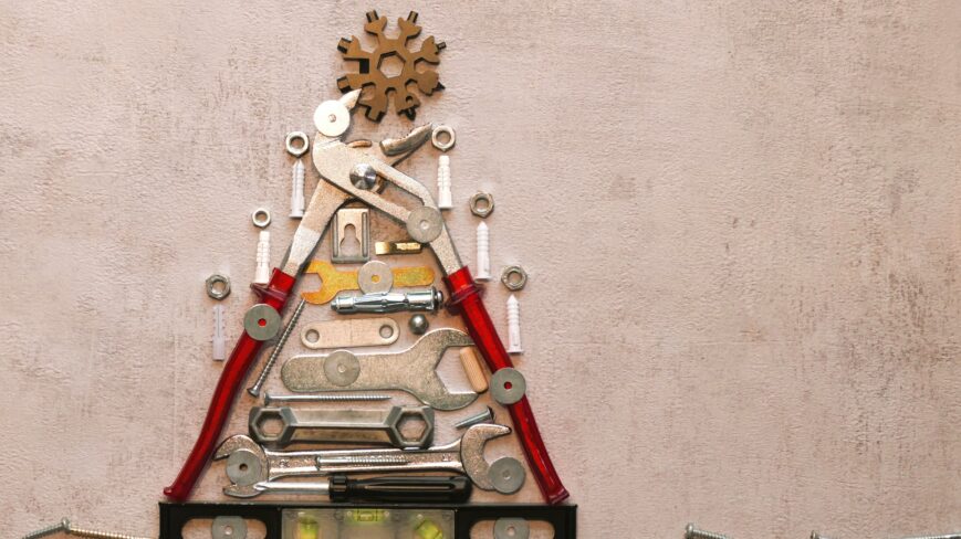 Erilaisia ruuveja ja työkaluja esillä betonin päällä.